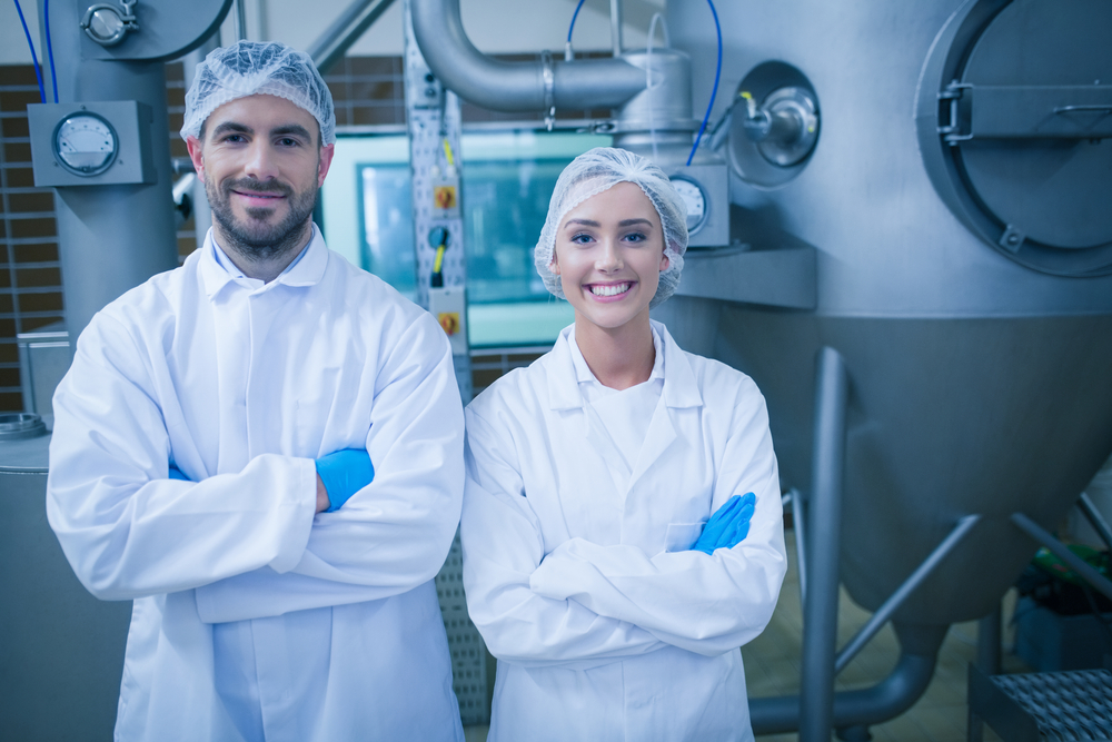 Food technicians smiling at camera in a food processing plant